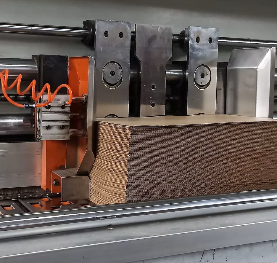 Engenheiro de produção supervisionando a qualidade do papelão em uma fábrica de embalagens.